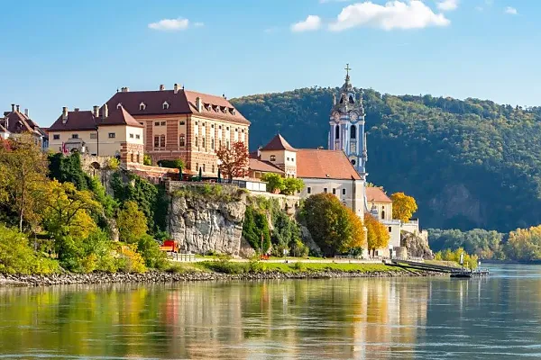 Die im Bild gezeigte Szene stellt das historische Stift Dürnstein und die Ruine der Burg Dürnstein in der Wachau am Ufer der Donau dar.