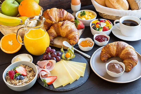 Das Bild zeigt ein reichhaltiges und abwechslungsreiches Frühstücksbuffet, das eine Mischung aus süßen und herzhaften Speisen bietet.