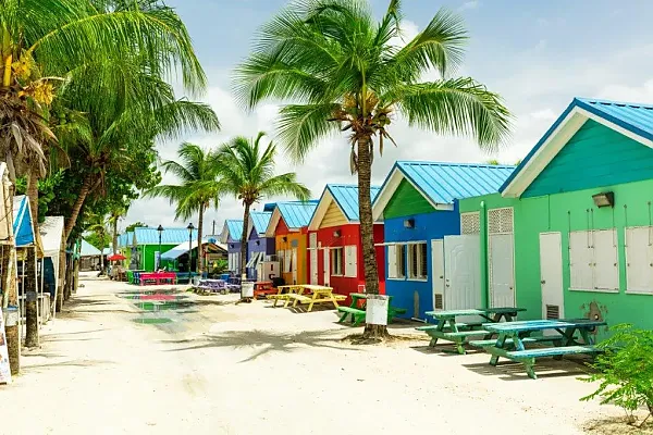 Das Bild zeigt farbenfrohe Strandhütten auf Barbados, einer Insel in der Karibik, die für ihre weißen Sandstrände und türkisfarbenes Wasser bekannt ist