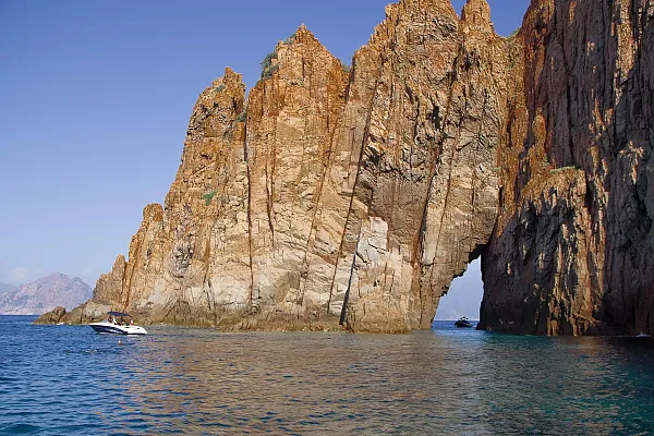 Das Bild zeigt die beeindruckenden roten Felsen der Calanques de Piana auf Korsika, Frankreich.